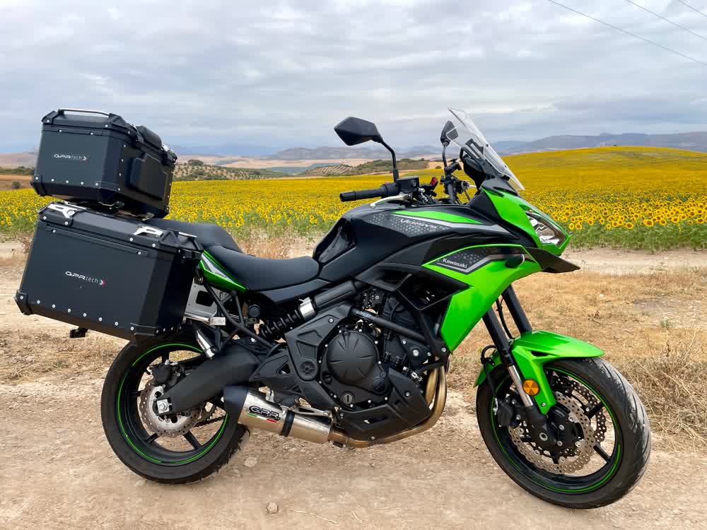 Kawasaki Versys 650 de un cliente con baúl y maletas GPR Tech y escape GPR en un campo de girasoles