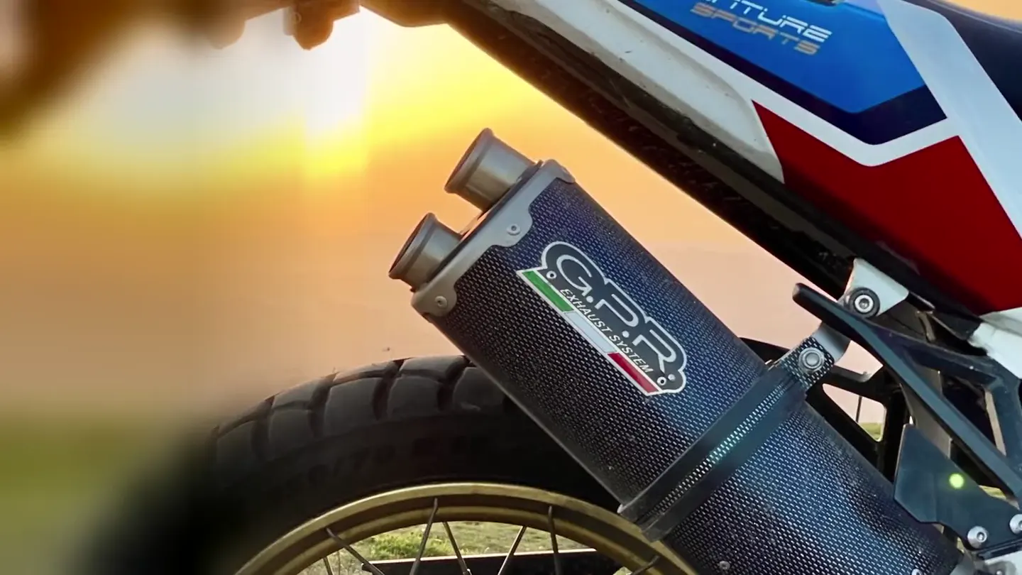Escape GPR de doble salida en carbono con el atardecer de fondo